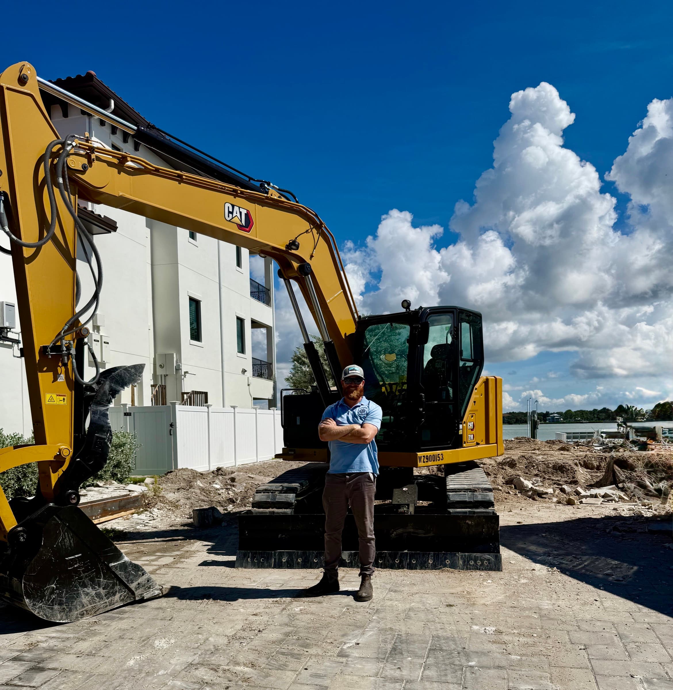 Joe Burns standing in front of Mojo excavation equipment on a Tampa Bay jobsite