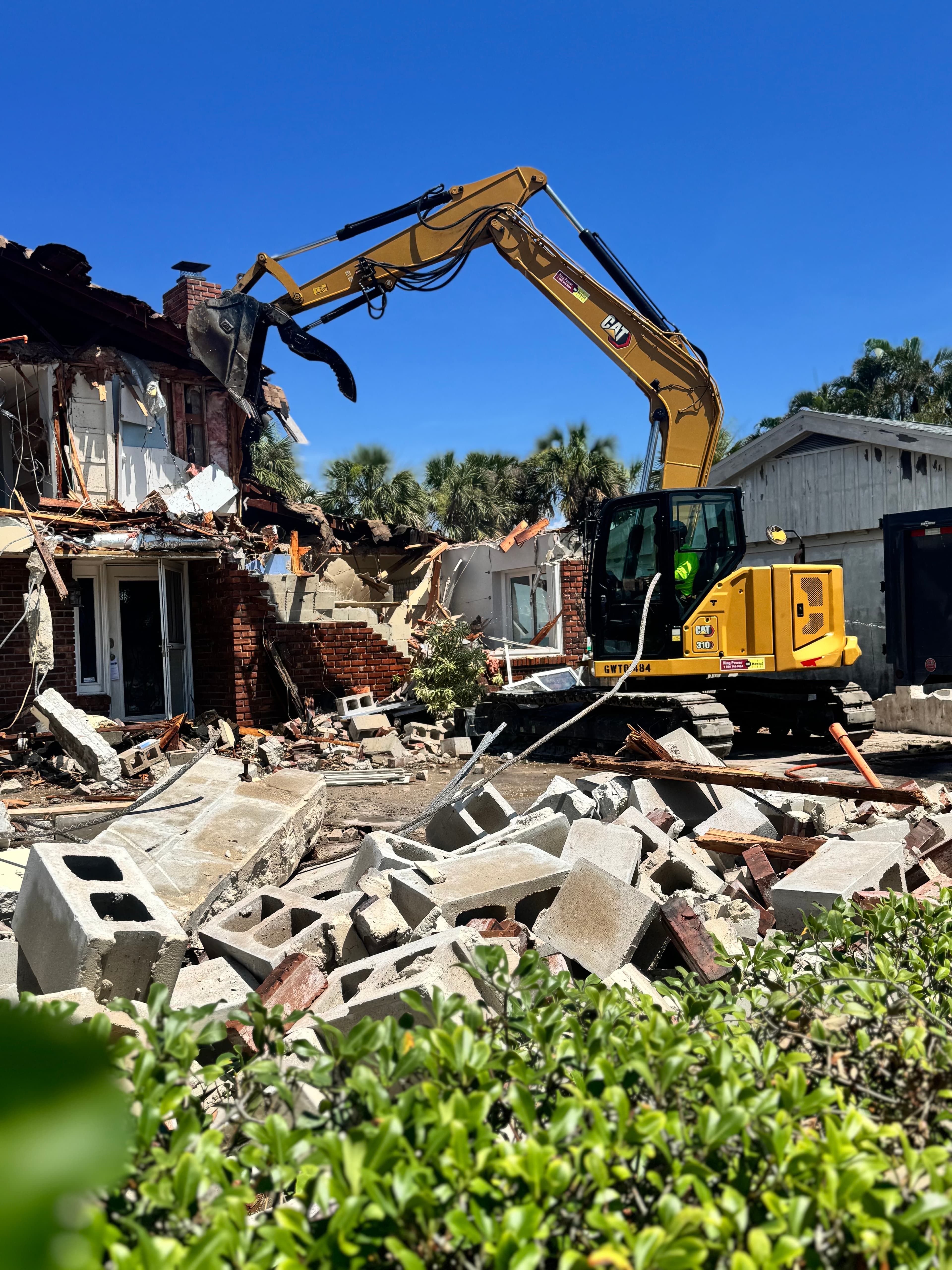 Excavator performing residential demolition and debris removal